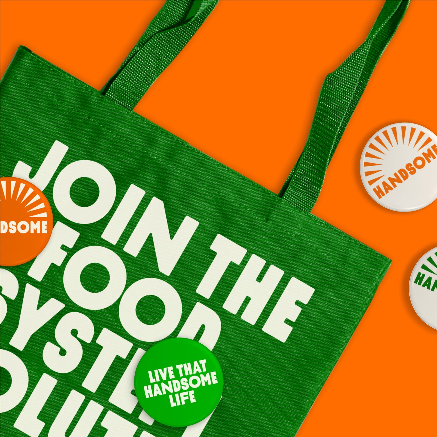 A bright green tote bag with bold text, "Join the Food System Revolution," alongside Handsome Brook Farms branded buttons.