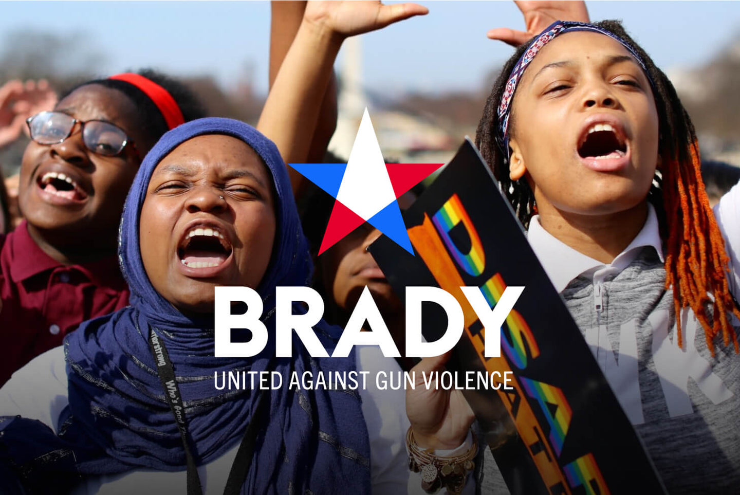 A group of passionate protesters chant and hold signs at a rally, with the 'Brady: United Against Gun Violence' logo overlaid in the center.